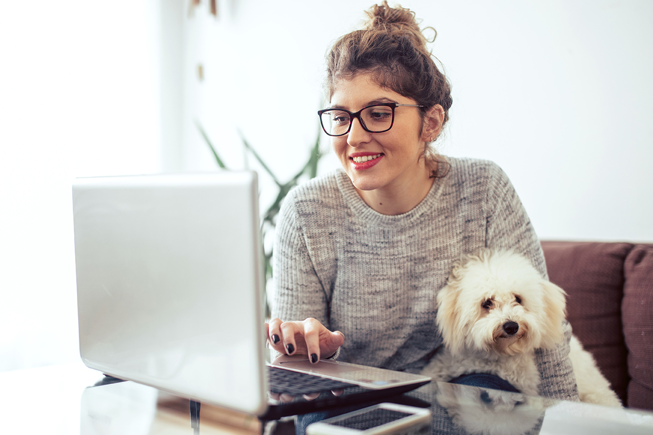 woman with white dog at computer